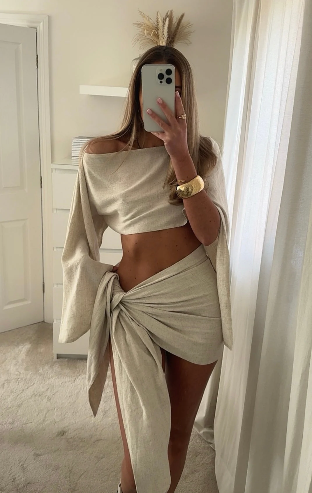 Two-piece linen sarong set featuring a draped, off-shoulder crop top and a wrap mini skirt tied at the hip. Breathable, lightweight fabric and an airy silhouette create a relaxed yet polished look for beach, resort and warm-weather outings.
