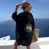 Aisling eye-catching blouse, an oversized button-up with lightweight crinkled texture and shimmering sequin-and-bead evil-eye motif on the back; relaxed drop-shoulder fit in black or white, ideal as a beach coverup or for casual chic layers.