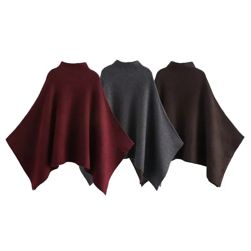 Alannah dark brown knit poncho cape featuring a refined high neckline and fluid, side-draped silhouette. Soft, medium-weight knit provides cozy warmth and effortless layering over jeans, tailored trousers or dresses for elevated everyday looks.