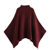 Alannah dark brown knit poncho cape featuring a refined high neckline and fluid, side-draped silhouette. Soft, medium-weight knit provides cozy warmth and effortless layering over jeans, tailored trousers or dresses for elevated everyday looks.