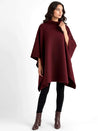 Alannah dark brown knit poncho cape featuring a refined high neckline and fluid, side-draped silhouette. Soft, medium-weight knit provides cozy warmth and effortless layering over jeans, tailored trousers or dresses for elevated everyday looks.