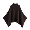 Alannah dark brown knit poncho cape featuring a refined high neckline and fluid, side-draped silhouette. Soft, medium-weight knit provides cozy warmth and effortless layering over jeans, tailored trousers or dresses for elevated everyday looks.