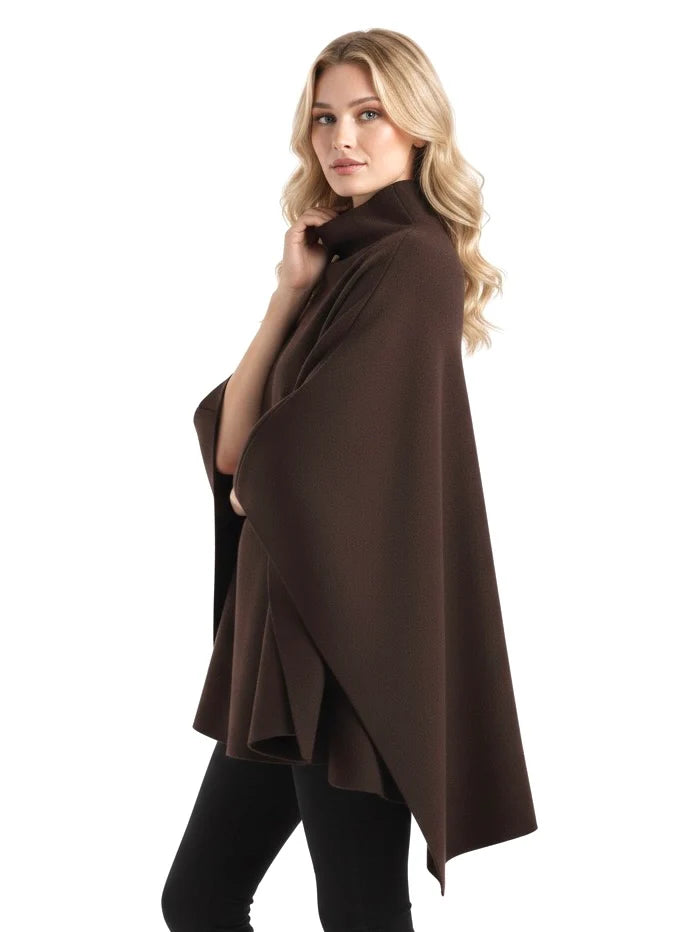 Alannah dark brown knit poncho cape featuring a refined high neckline and fluid, side-draped silhouette. Soft, medium-weight knit provides cozy warmth and effortless layering over jeans, tailored trousers or dresses for elevated everyday looks.