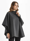 Alannah dark brown knit poncho cape featuring a refined high neckline and fluid, side-draped silhouette. Soft, medium-weight knit provides cozy warmth and effortless layering over jeans, tailored trousers or dresses for elevated everyday looks.