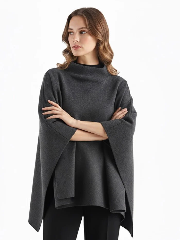 Alannah dark brown knit poncho cape featuring a refined high neckline and fluid, side-draped silhouette. Soft, medium-weight knit provides cozy warmth and effortless layering over jeans, tailored trousers or dresses for elevated everyday looks.