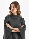 Alannah dark brown knit poncho cape featuring a refined high neckline and fluid, side-draped silhouette. Soft, medium-weight knit provides cozy warmth and effortless layering over jeans, tailored trousers or dresses for elevated everyday looks.