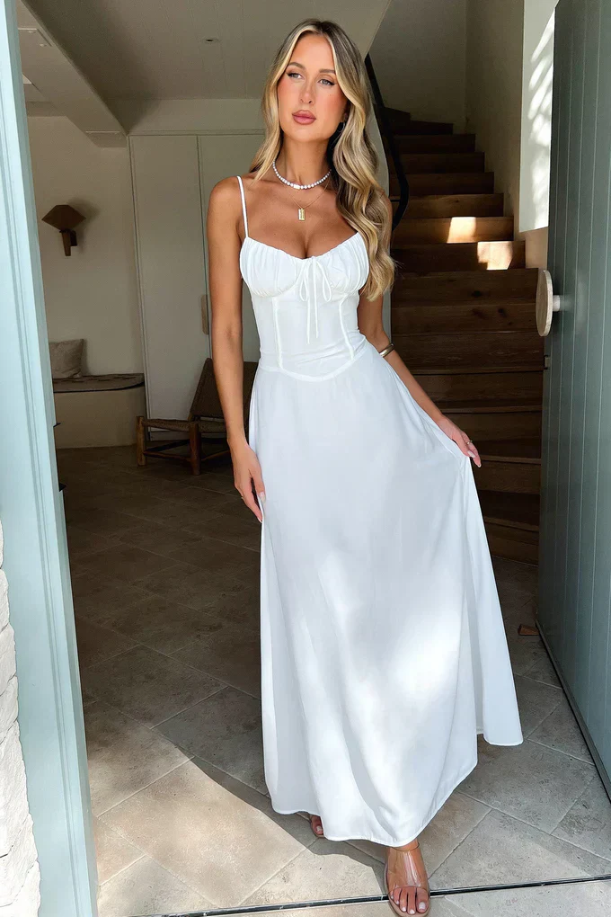 Maxi dress with delicate straps, ruched bust and lace-up back for a custom fit, finished with a flowing A-line skirt. Lightweight, breathable fabric offers graceful movement for weddings, soirées, parties or elegant daytime wear.