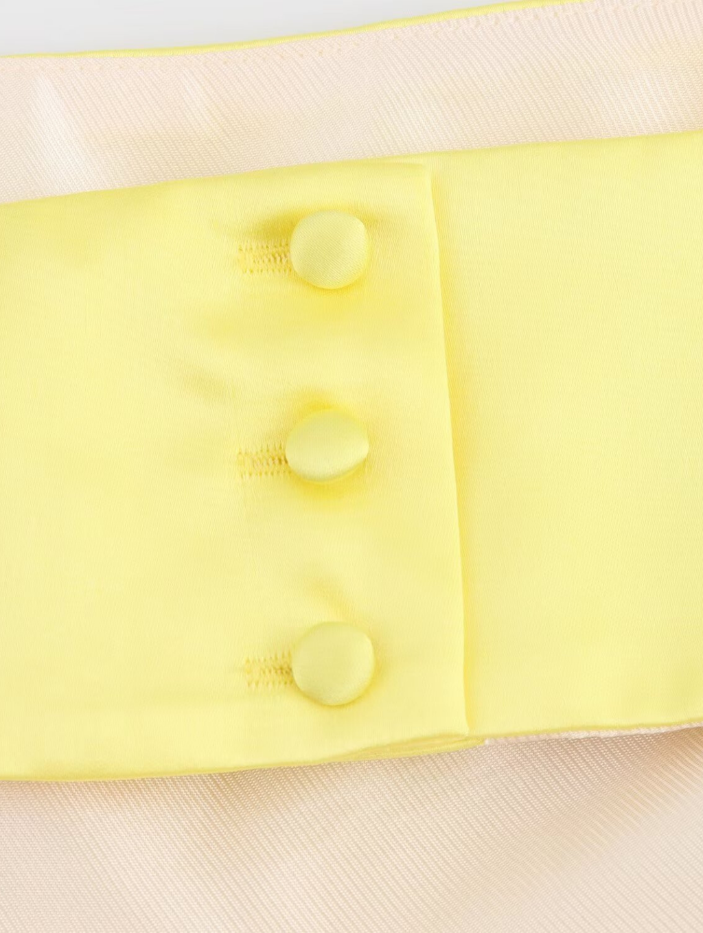 Amalfi Satin Mini Dress in lemon yellow with structured pleated bandeau bodice, adjustable thin straps, open back with criss-cross ties and a flared double-layered skirt. Polyester satin offers fluid movement for parties, vacations and seaside events.