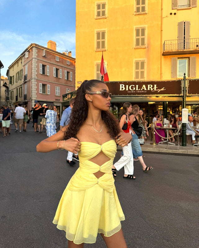 Amara strapless mini dress with triple twist-front detail, cutout waist and flowy A-line skirt. Lightweight polyester with elastane and an elasticized back for a flexible, comfortable fit at vacations, rooftop parties and sunset dinners.