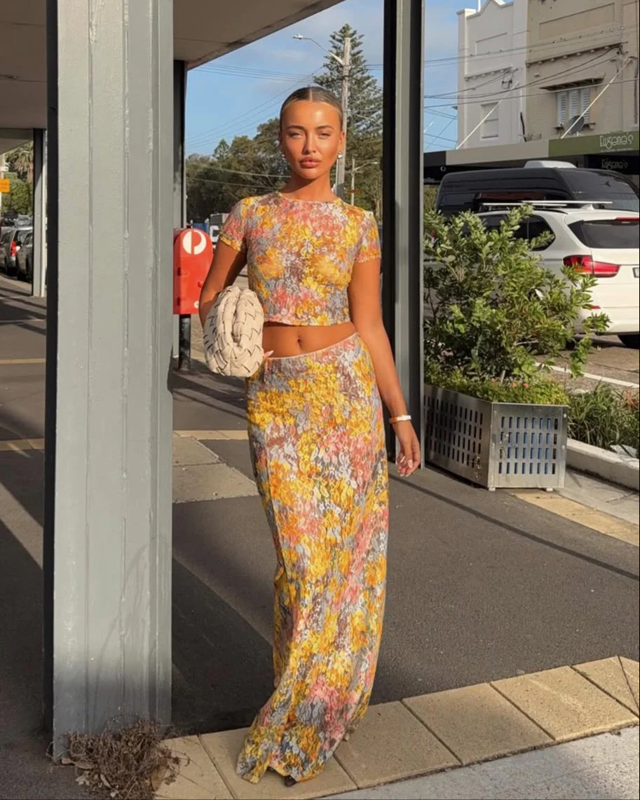 Amaris floral print two piece set featuring a short-sleeve cropped top and matching column maxi skirt in multicolor yellow, pink and grey. Body-skimming silhouette with a lightweight feel, ideal for casual days, brunch and vacations.