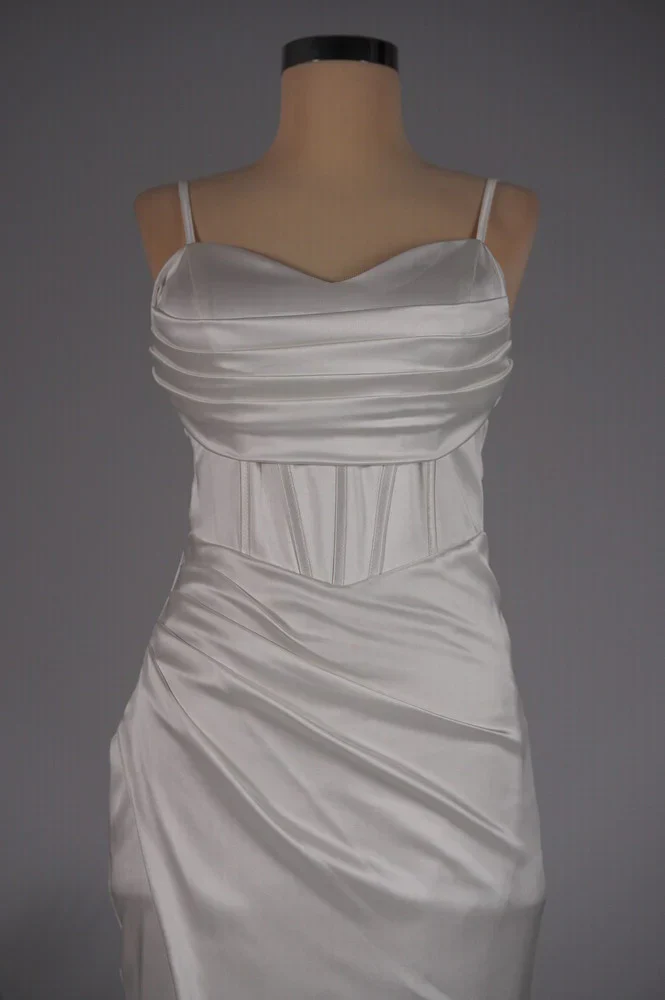 Bella satin corset slit gown featuring slim straps, a corset-style bodice and thigh-high slit. Gentle ruching defines the waist while stretch and a light drape contour the body without showing folds. Composition: Cotton, Polyester, Elastane, Satin.