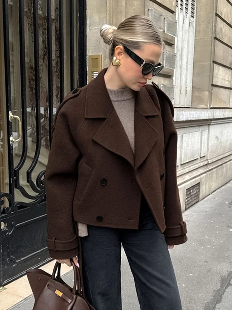 Camille cropped trench jacket in brown wool blend featuring wide lapels, double-breasted buttons, epaulettes and adjustable cuff tabs. Soft, structured fabric and a waist-flattering length for refined layering over knits, dresses or trousers.