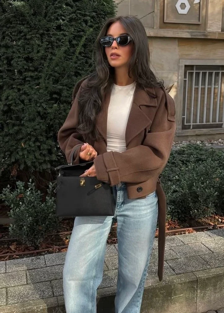 Camille cropped trench jacket in brown wool blend featuring wide lapels, double-breasted buttons, epaulettes and adjustable cuff tabs. Soft, structured fabric and a waist-flattering length for refined layering over knits, dresses or trousers.