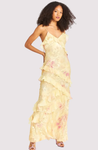 Maxi dress with delicate straps and cascading ruffle tiers, featuring a soft floral pattern and a graceful V neckline; lightweight, fluid drape creates feminine movement, ideal for garden parties, weddings, evening dinners or elegant daytime events.