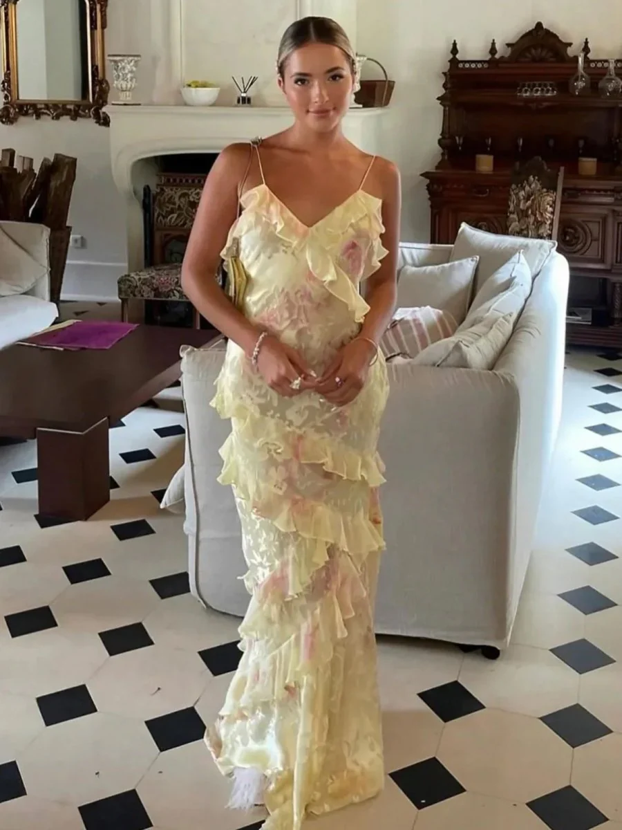 Maxi dress with delicate straps and cascading ruffle tiers, featuring a soft floral pattern and a graceful V neckline; lightweight, fluid drape creates feminine movement, ideal for garden parties, weddings, evening dinners or elegant daytime events.