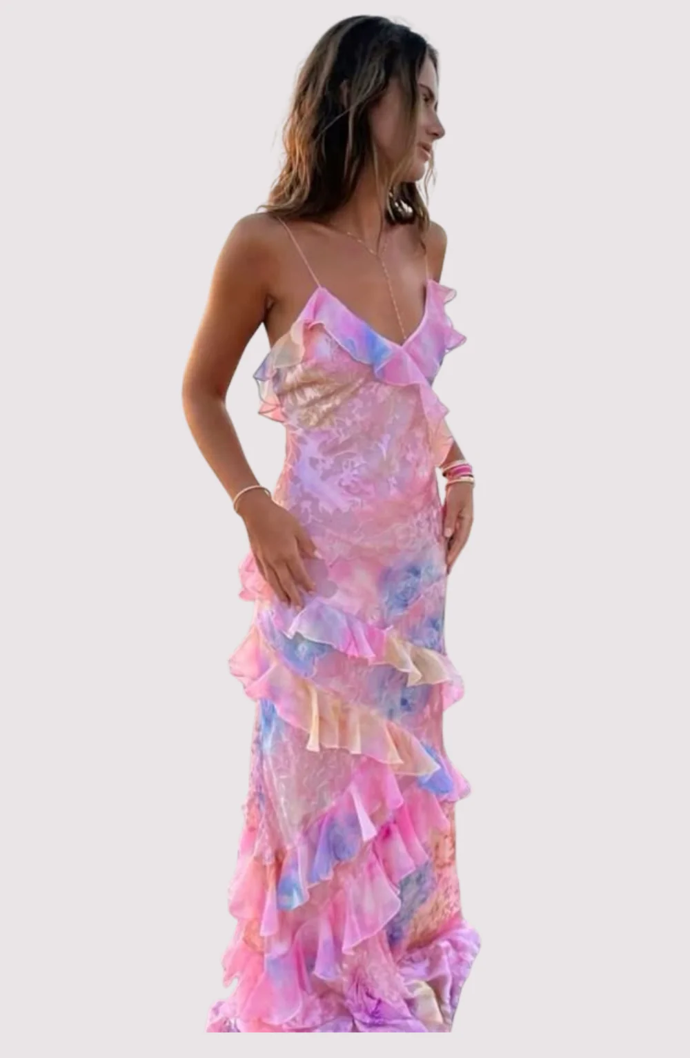 Maxi dress with delicate straps and cascading ruffle tiers, featuring a soft floral pattern and a graceful V neckline; lightweight, fluid drape creates feminine movement, ideal for garden parties, weddings, evening dinners or elegant daytime events.