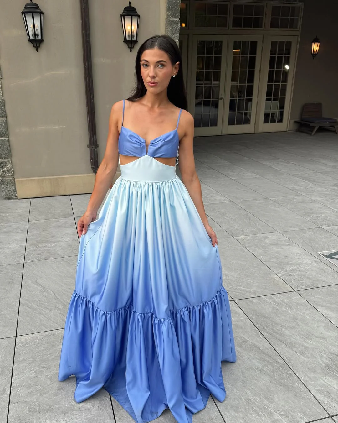 Catarina ombré cutout maxi dress blending sky blue to deep cobalt, featuring a soft triangle bust with front knot, side waist cutouts, adjustable spaghetti straps, and a high-waisted gathered tiered skirt in lightweight polyester with a subtle sheen.