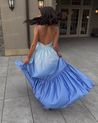 Catarina ombré cutout maxi dress blending sky blue to deep cobalt, featuring a soft triangle bust with front knot, side waist cutouts, adjustable spaghetti straps, and a high-waisted gathered tiered skirt in lightweight polyester with a subtle sheen.