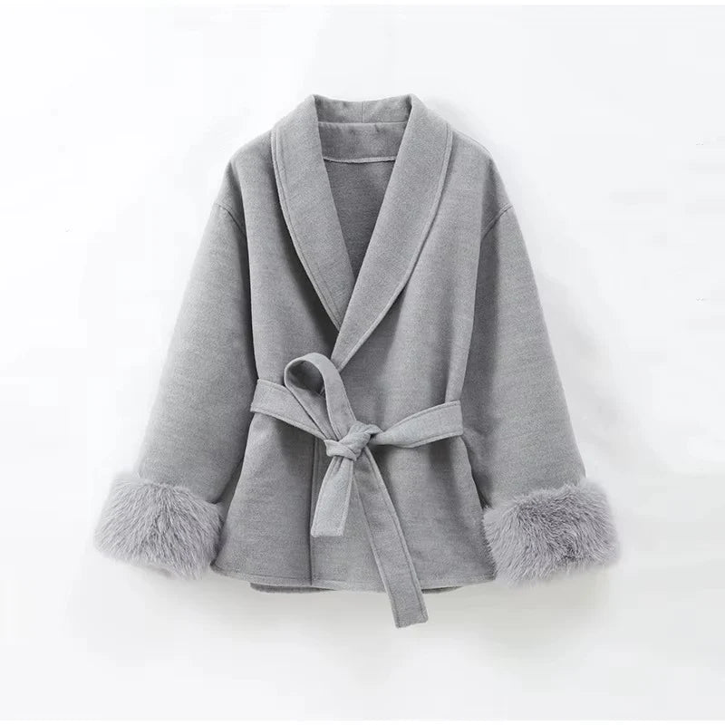 Celine wool-blend belted coat featuring a wrap front, wide lapels and waist-defining tie belt with statement faux fur cuffs. Soft, warm and durable outer layer that elevates autumn-winter outfits from tailored trousers to knit dresses with Parisian elegance.