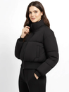 Claire cropped puffer jacket in black, featuring a high padded collar, zip fastening, elasticated cuffs and a smooth polyester shell with lightweight fibre filling. Sleek, warm and non-bulky—ideal over high-waist denim, skirts or tailored trousers.