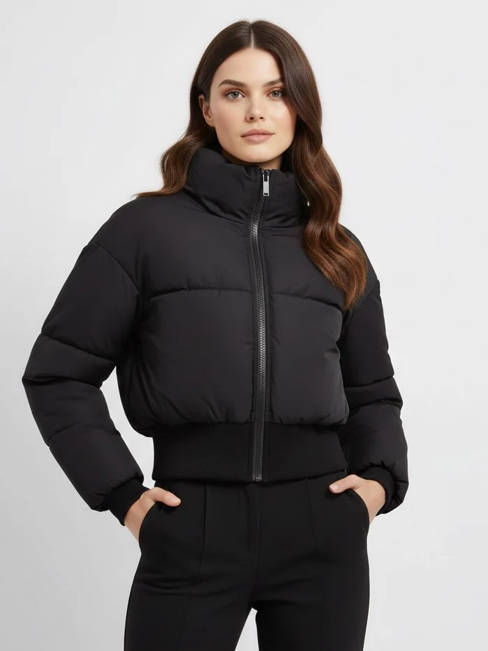 Claire cropped puffer jacket in black, featuring a high padded collar, zip fastening, elasticated cuffs and a smooth polyester shell with lightweight fibre filling. Sleek, warm and non-bulky—ideal over high-waist denim, skirts or tailored trousers.