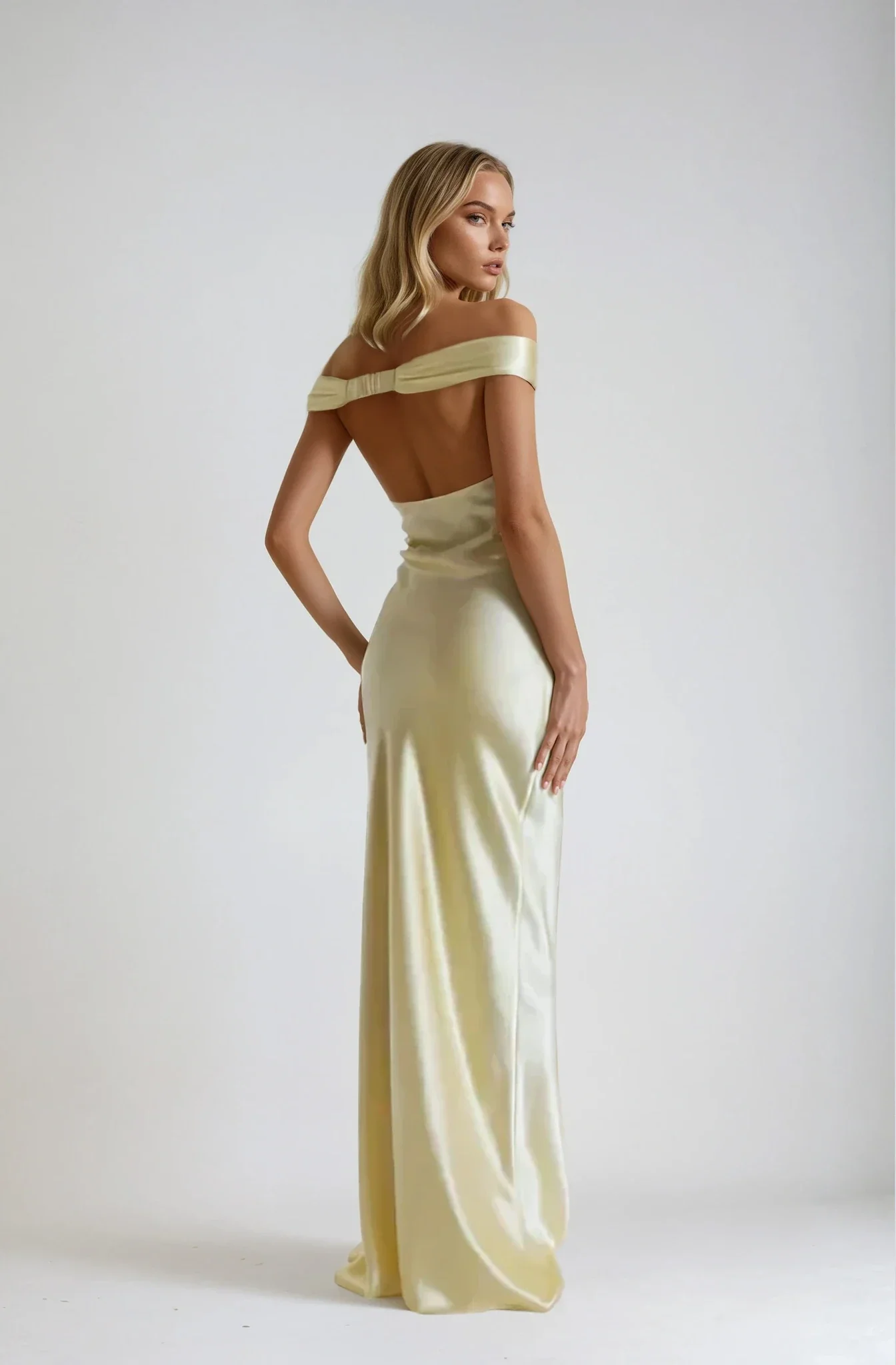 Emory satin backless maxi dress featuring an off-shoulder band, soft twist at the bust, and a sleek, body-skimming silhouette that falls to the floor. Lightweight satin with a refined sheen—ideal for weddings, formal dinners, and elegant evening events.