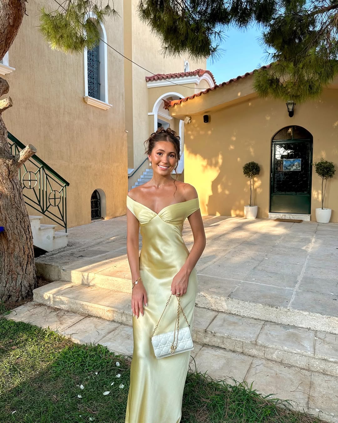 Emory satin backless maxi dress featuring an off-shoulder band, soft twist at the bust, and a sleek, body-skimming silhouette that falls to the floor. Lightweight satin with a refined sheen—ideal for weddings, formal dinners, and elegant evening events.