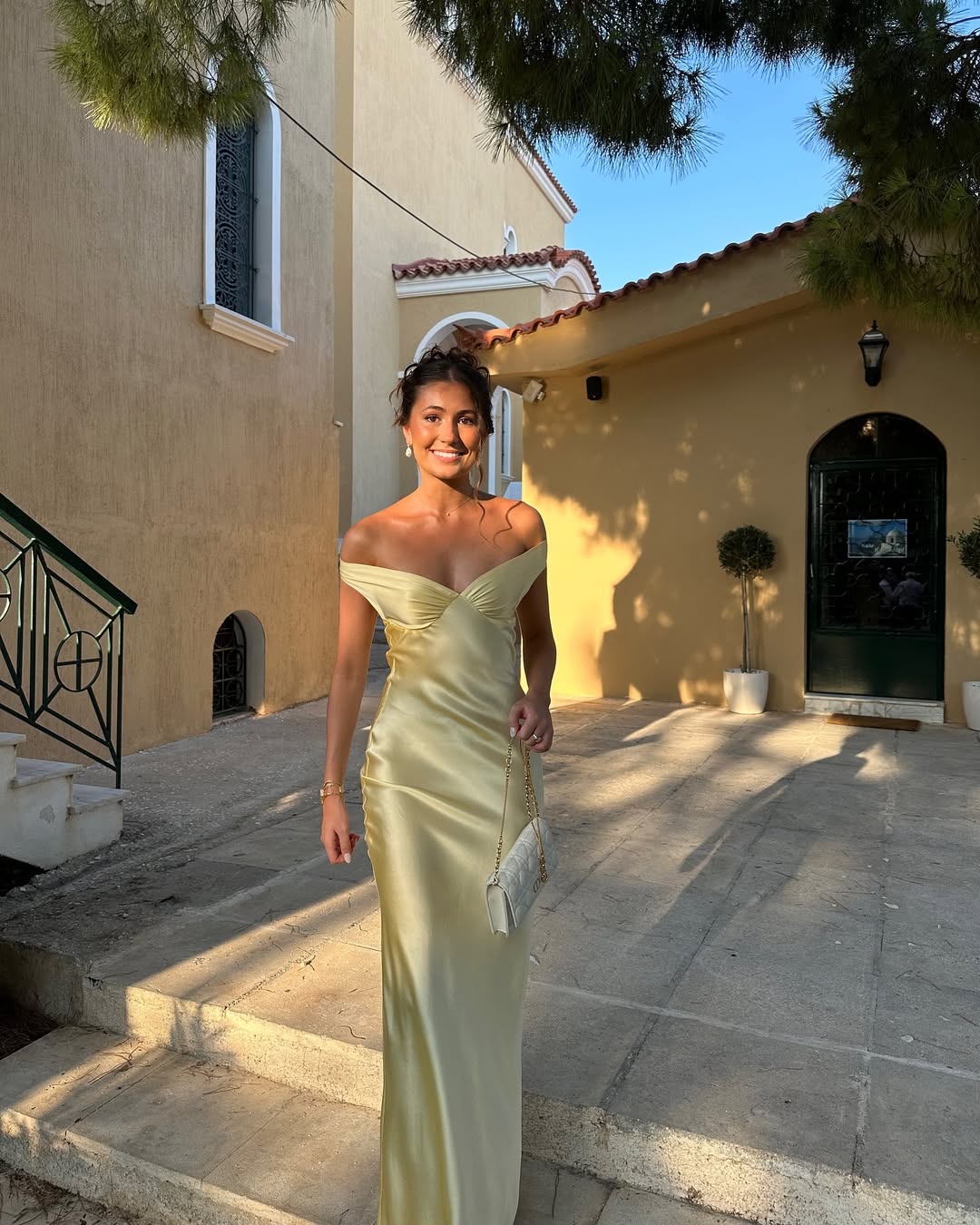 Emory satin backless maxi dress featuring an off-shoulder band, soft twist at the bust, and a sleek, body-skimming silhouette that falls to the floor. Lightweight satin with a refined sheen—ideal for weddings, formal dinners, and elegant evening events.