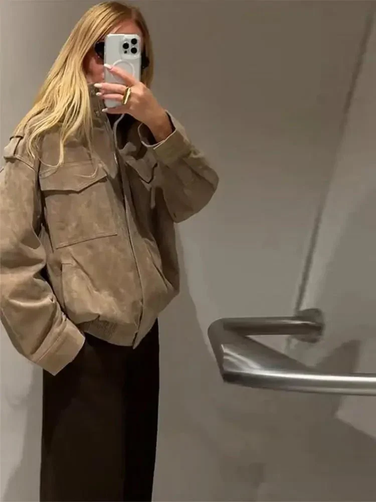 Women’s cropped moto jacket in beige, made from suede-like fabric with a lapel collar, shoulder epaulets and large front pockets. Softly structured silhouette layers over knits or tees, adding a refined, vintage-utility touch for cool-weather styling.