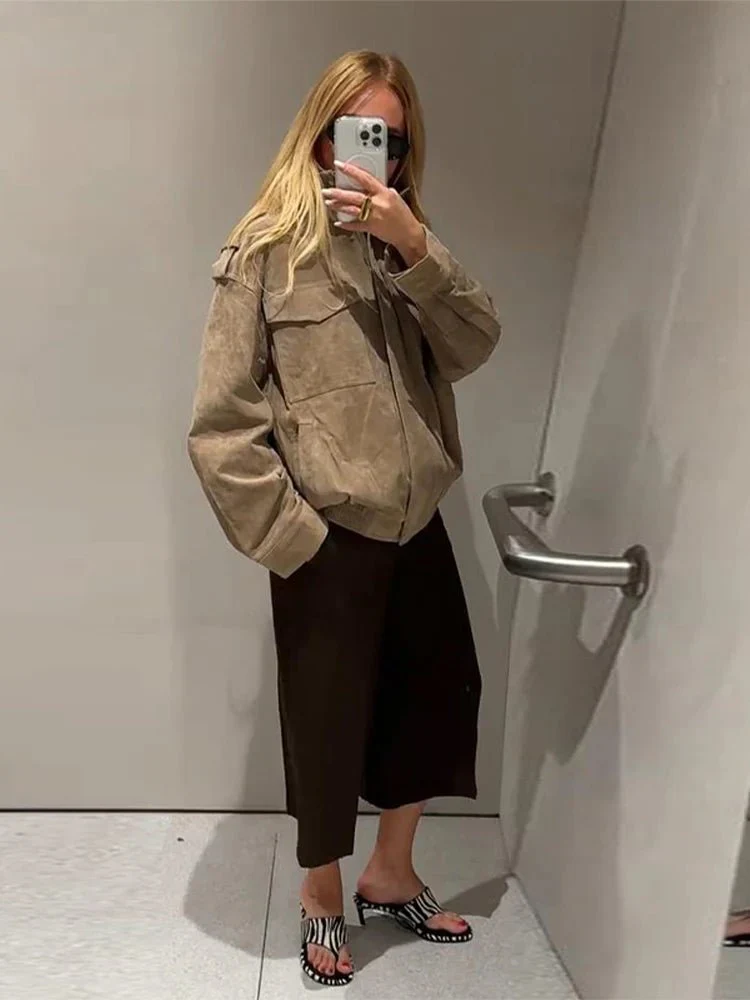 Women’s cropped moto jacket in beige, made from suede-like fabric with a lapel collar, shoulder epaulets and large front pockets. Softly structured silhouette layers over knits or tees, adding a refined, vintage-utility touch for cool-weather styling.