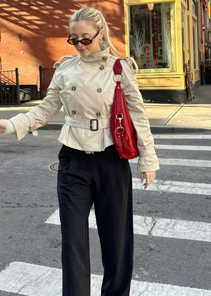 Isabelle high-neck belted trench coat in premium cotton blend with structured stand collar, double-breasted buttons, epaulettes and adjustable cuffs. Tailored silhouette layers over dresses, denim or trousers for refined autumn-winter style.