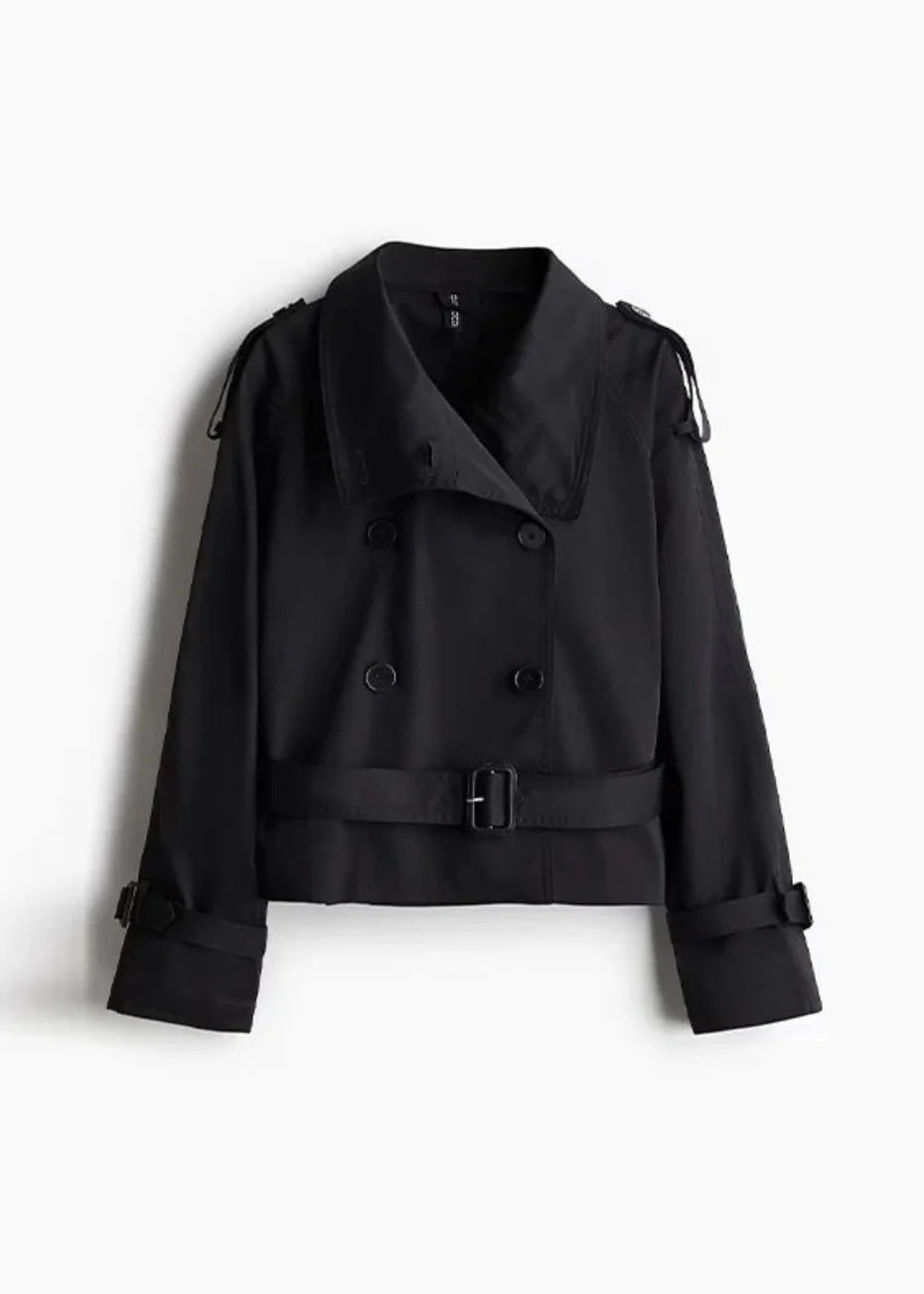 Isabelle high-neck belted trench coat in premium cotton blend with structured stand collar, double-breasted buttons, epaulettes and adjustable cuffs. Tailored silhouette layers over dresses, denim or trousers for refined autumn-winter style.