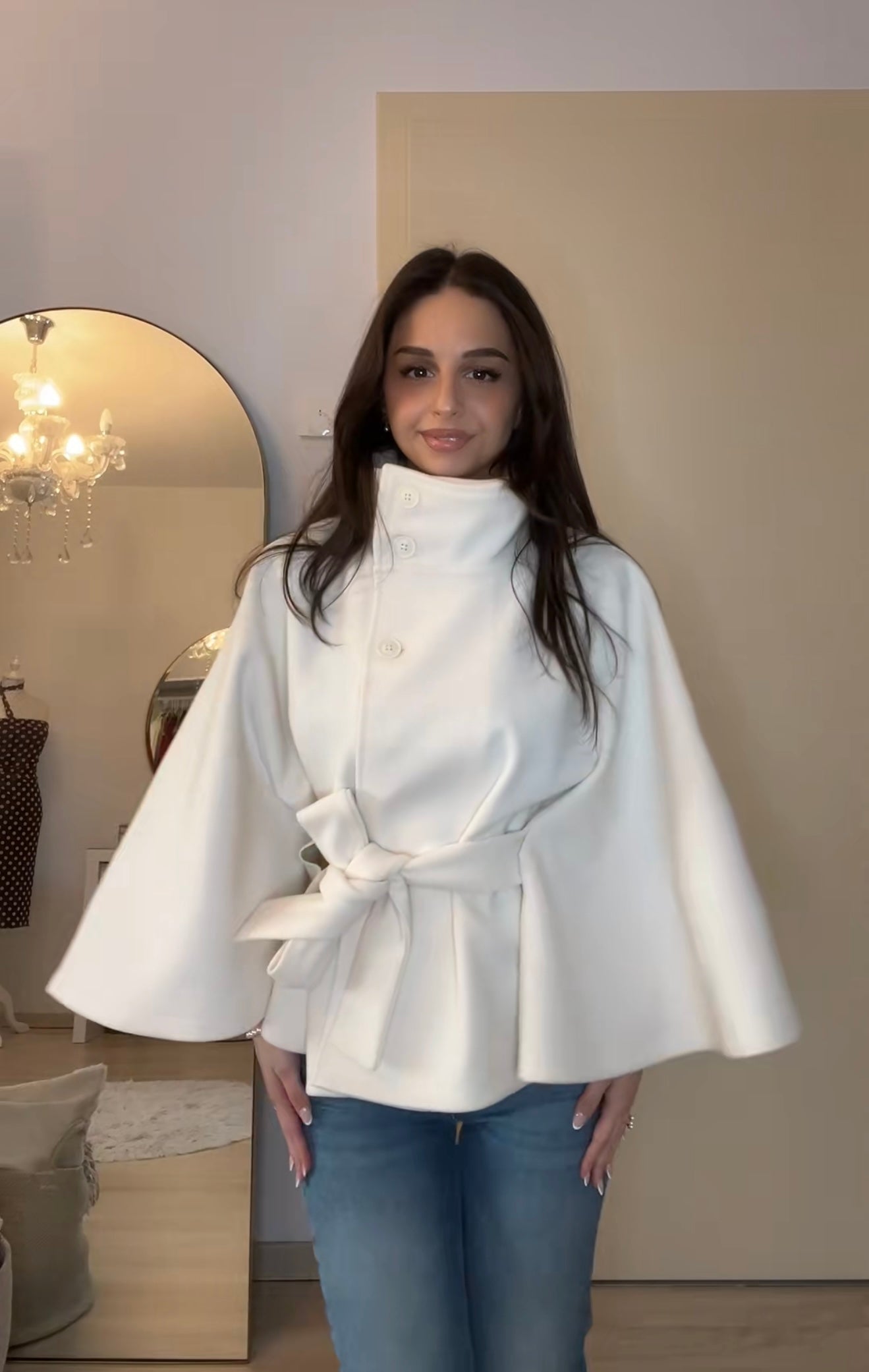 High-neck belted cape jacket in camel wool blend with buttoned collar, cape silhouette and waist-defining tie belt. Soft, warm and comfortable layering piece for autumn and winter, styled over knits or dresses for timeless elegance.