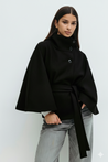 High-neck belted cape jacket in camel wool blend with buttoned collar, cape silhouette and waist-defining tie belt. Soft, warm and comfortable layering piece for autumn and winter, styled over knits or dresses for timeless elegance.