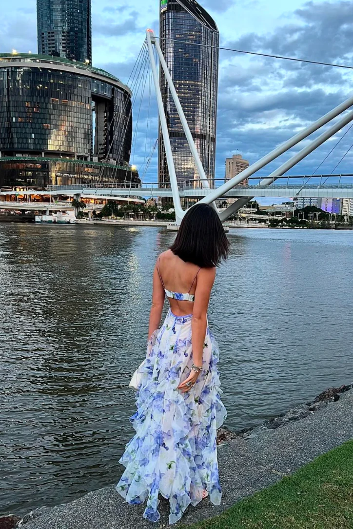 Jackie Floral Maxi Dress with adjustable spaghetti straps, softly shaped bodice and flowing ruffle layers. Lightweight, sheer fabric and a refined side slit create romantic movement; finished with a concealed zip for a clean, polished look.