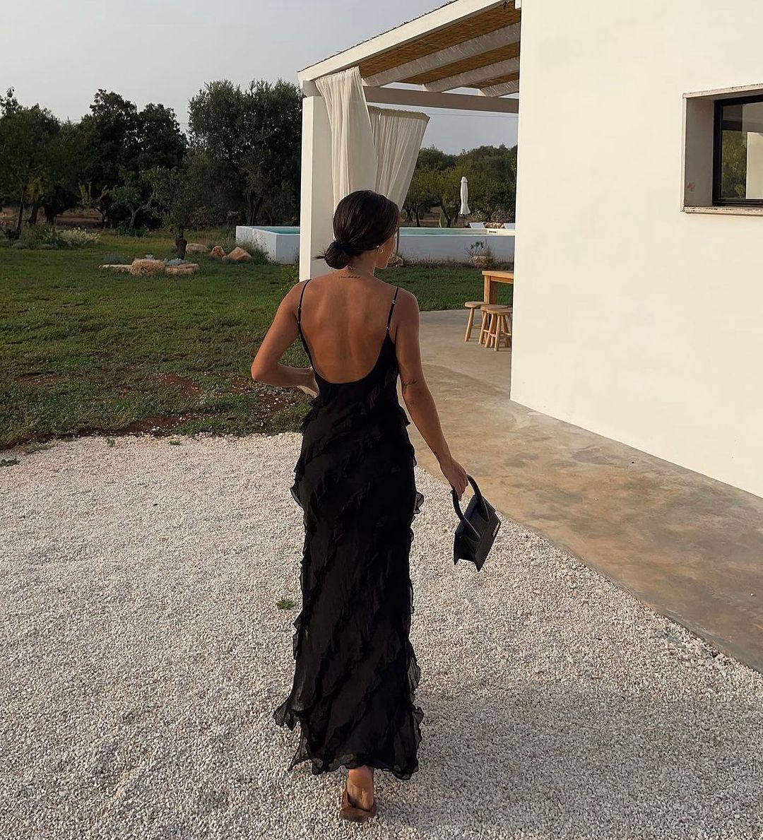 Women’s elegant tulle maxi dress with slender straps, open back and ruched waist. Floaty, ruffled texture and subtle side slit deliver graceful movement. A floor-skimming hem elongates for polished wedding or evening looks.