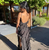 Women’s elegant tulle maxi dress with slender straps, open back and ruched waist. Floaty, ruffled texture and subtle side slit deliver graceful movement. A floor-skimming hem elongates for polished wedding or evening looks.