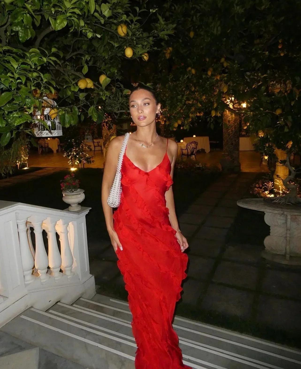 Women’s elegant tulle maxi dress with slender straps, open back and ruched waist. Floaty, ruffled texture and subtle side slit deliver graceful movement. A floor-skimming hem elongates for polished wedding or evening looks.