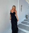 Women’s elegant tulle maxi dress with slender straps, open back and ruched waist. Floaty, ruffled texture and subtle side slit deliver graceful movement. A floor-skimming hem elongates for polished wedding or evening looks.