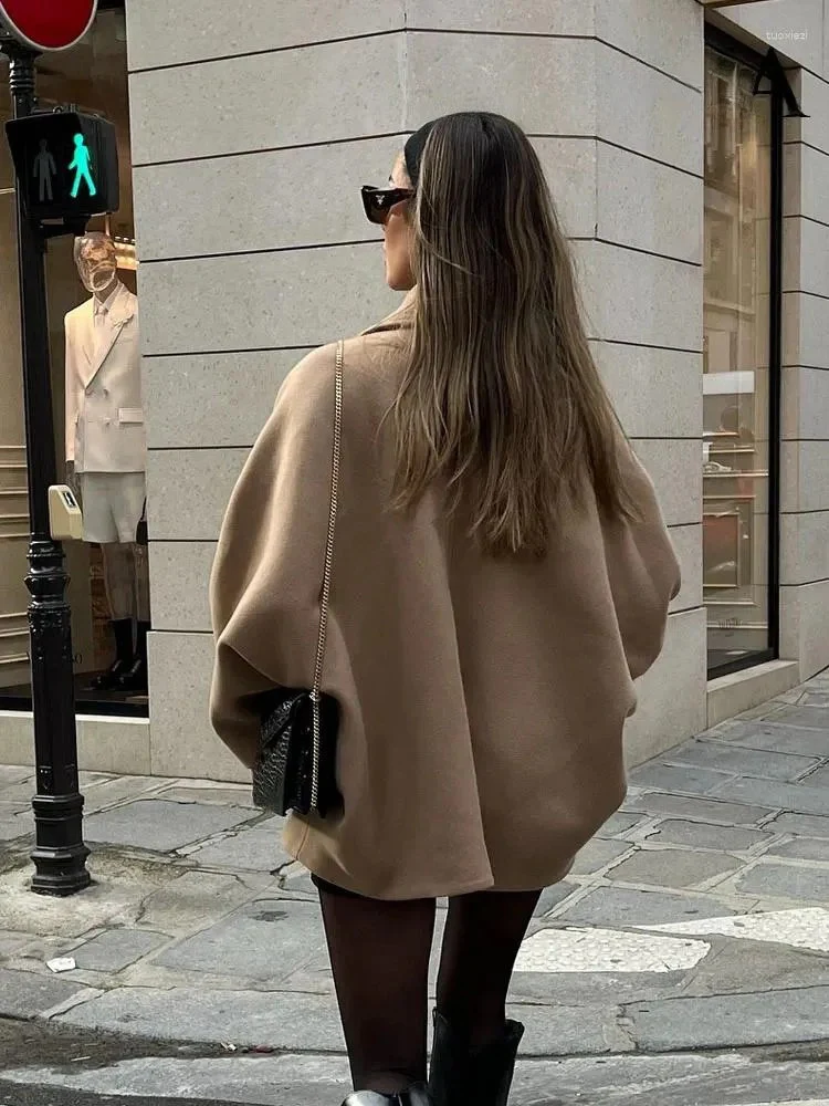 Women’s oversized collared coat in a hip-length cut with dropped shoulders, side slits, clean button front and deep hand pockets. Minimalist lines create a smooth drape over knitwear or dresses, delivering a refined, easy-to-style winter layer.