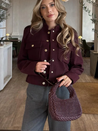 Lilly cropped jacket in deep burgundy featuring statement gold buttons, front flap pockets and a clean, collarless neckline. Soft yet structured woven fabric flatters the waist and layers over dresses, denim or tailoring for refined desk-to-dinner style.