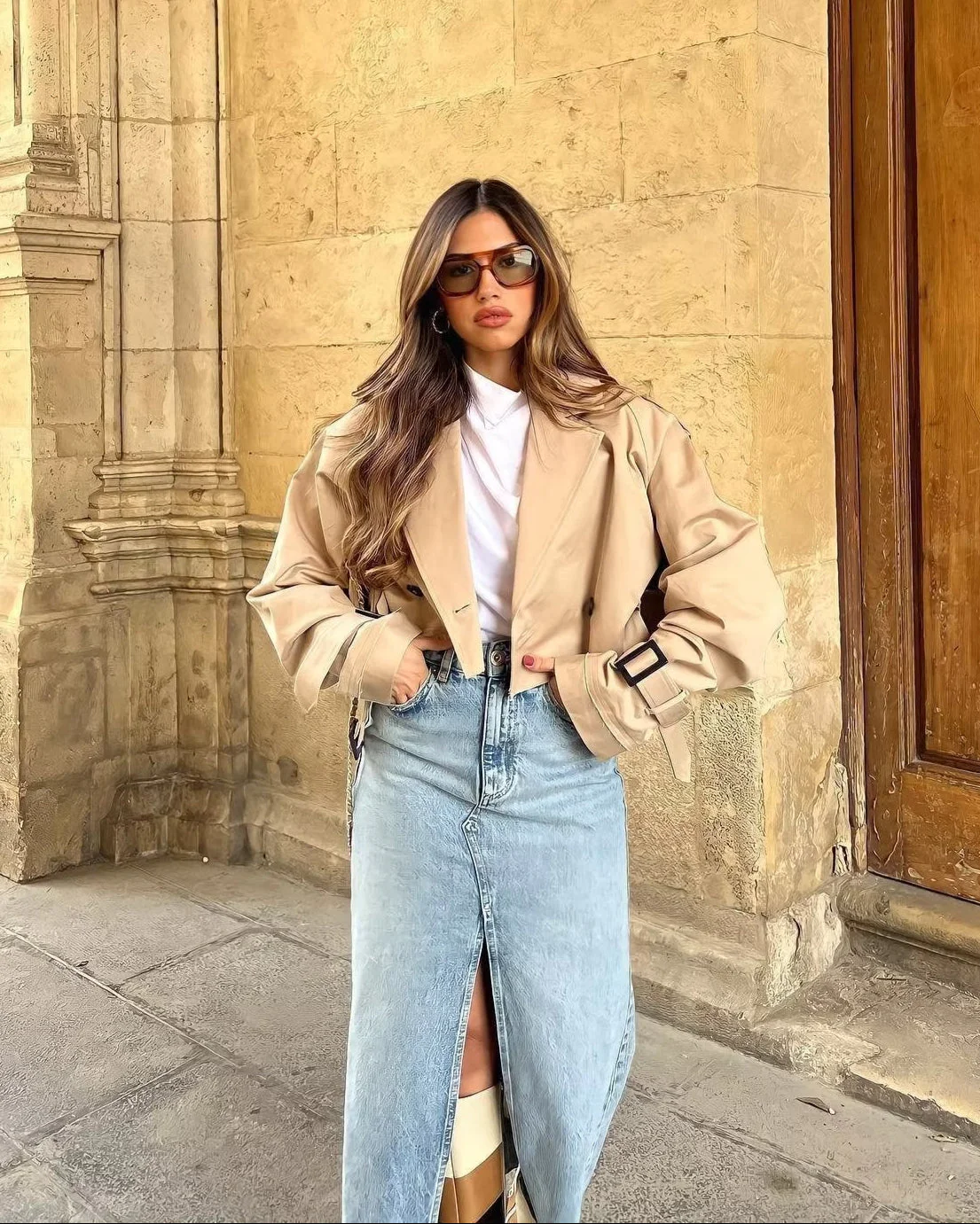 Cropped trench coat featuring a belted waist, subtle shoulder epaulettes, functional storm flap, cuff straps and deep front pockets. A hip-skimming, lightweight layer that pairs with high-waist trousers or dresses for effortless transitional styling.