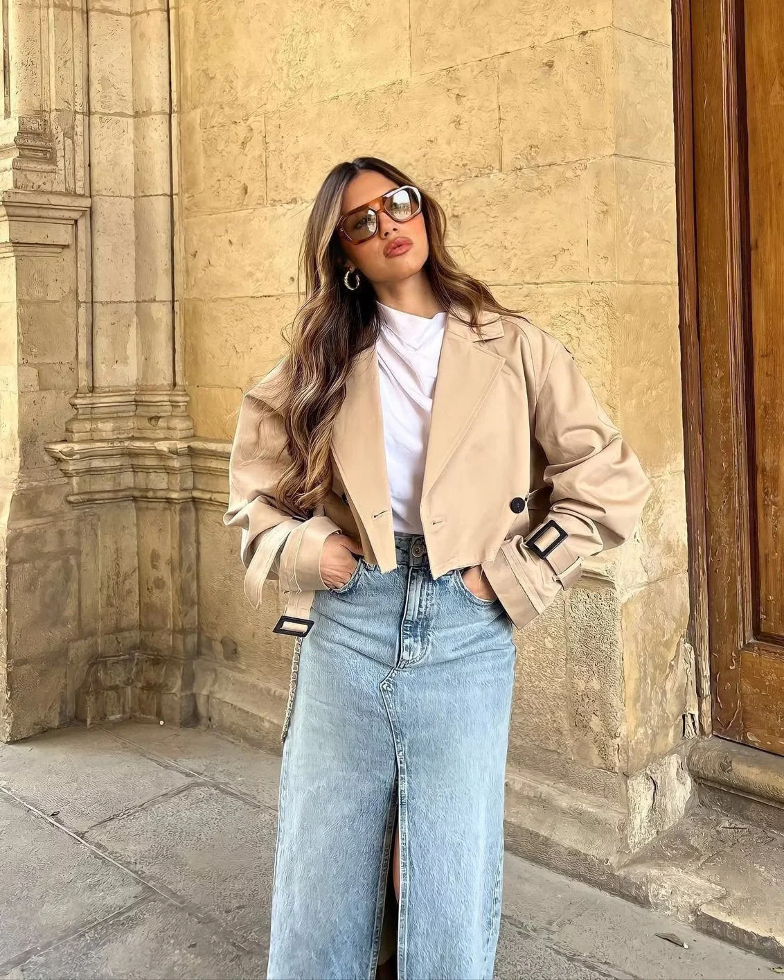 Cropped trench coat featuring a belted waist, subtle shoulder epaulettes, functional storm flap, cuff straps and deep front pockets. A hip-skimming, lightweight layer that pairs with high-waist trousers or dresses for effortless transitional styling.