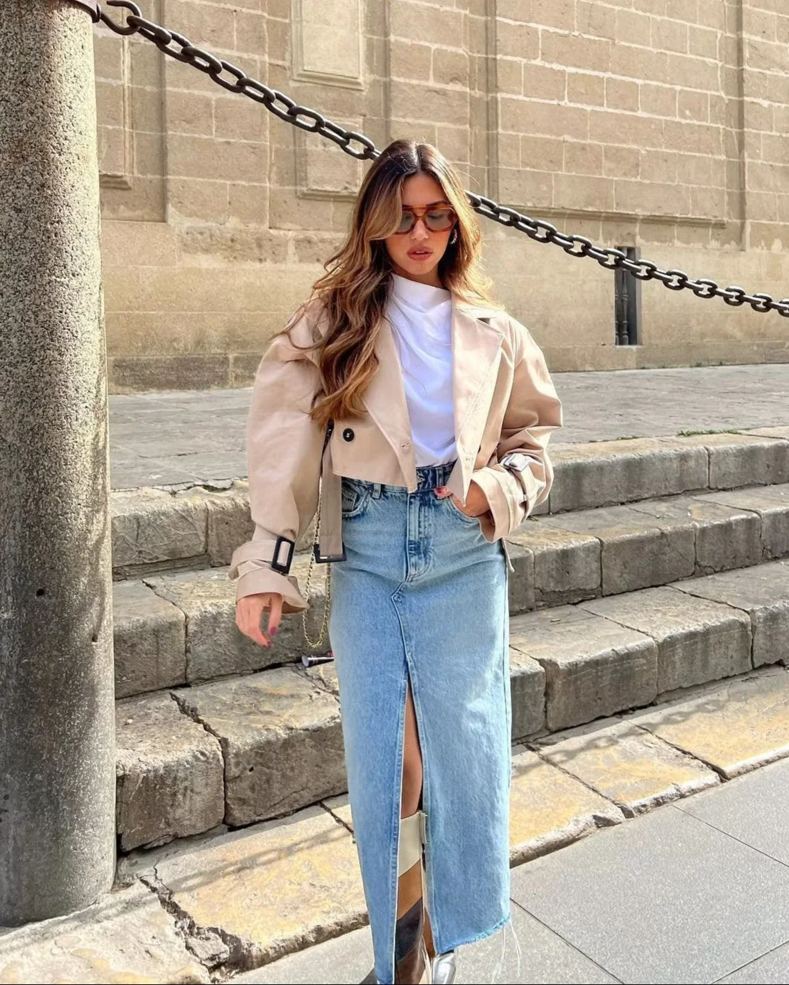 Cropped trench coat featuring a belted waist, subtle shoulder epaulettes, functional storm flap, cuff straps and deep front pockets. A hip-skimming, lightweight layer that pairs with high-waist trousers or dresses for effortless transitional styling.