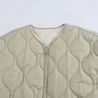 Soft beige quilted oversized jacket featuring wave-pattern stitching, rounded neckline, full front zip and two roomy front pockets. Polyester shell with lightweight fibre fill provides warmth without bulk and a relaxed drape for easy layering in cooler seasons.
