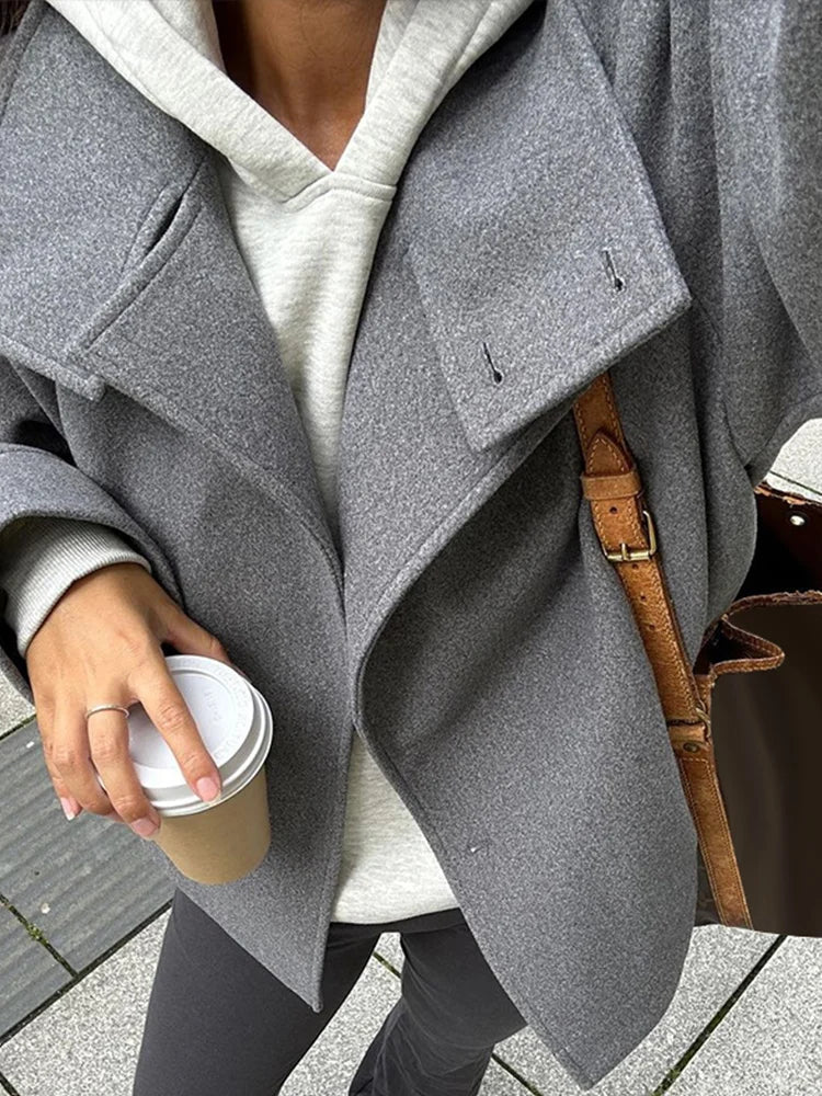 Martha High-Neck Wool-Blend Jacket featuring a structured stand collar, asymmetric button closure, smooth inner lining and a relaxed, slightly cropped silhouette. A warm yet polished layer that pairs with tailored trousers or high-waisted denim for transitional days.