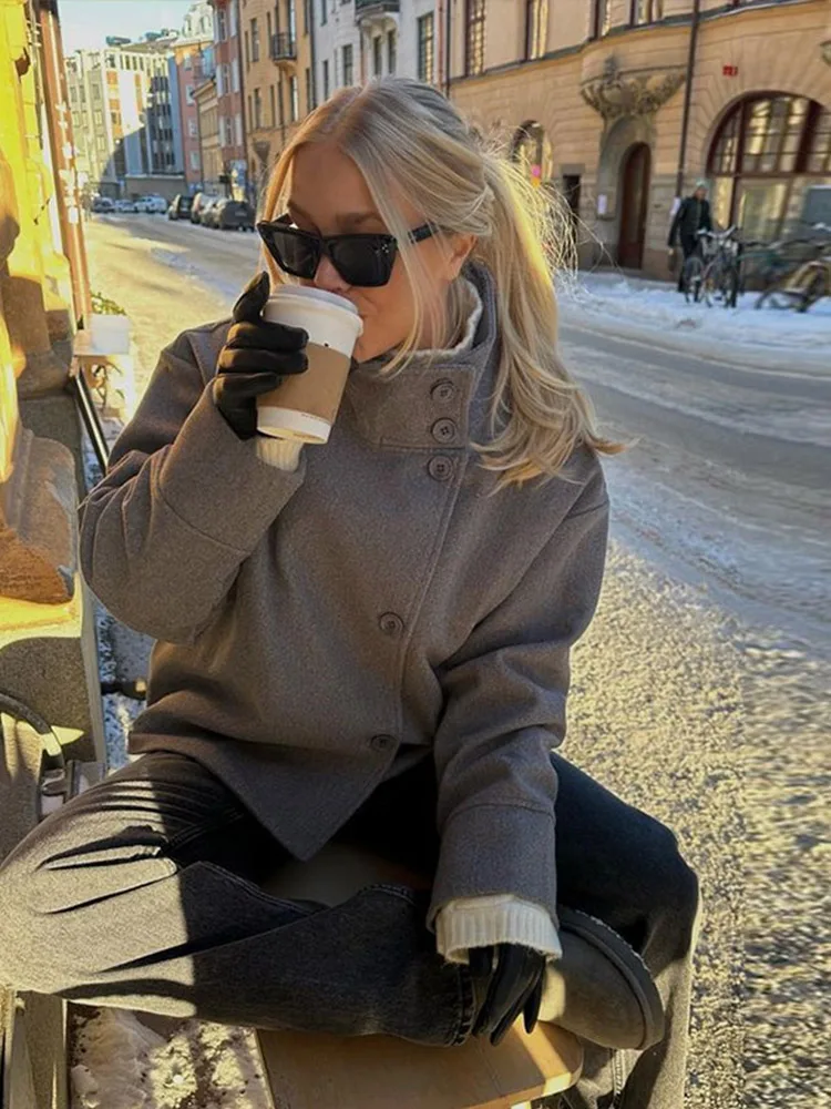 Martha High-Neck Wool-Blend Jacket featuring a structured stand collar, asymmetric button closure, smooth inner lining and a relaxed, slightly cropped silhouette. A warm yet polished layer that pairs with tailored trousers or high-waisted denim for transitional days.