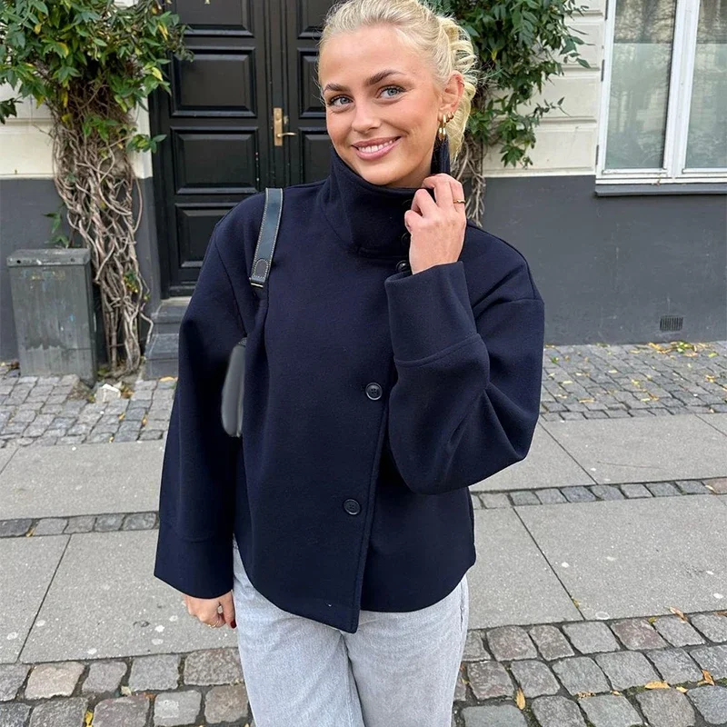 Martha High-Neck Wool-Blend Jacket featuring a structured stand collar, asymmetric button closure, smooth inner lining and a relaxed, slightly cropped silhouette. A warm yet polished layer that pairs with tailored trousers or high-waisted denim for transitional days.