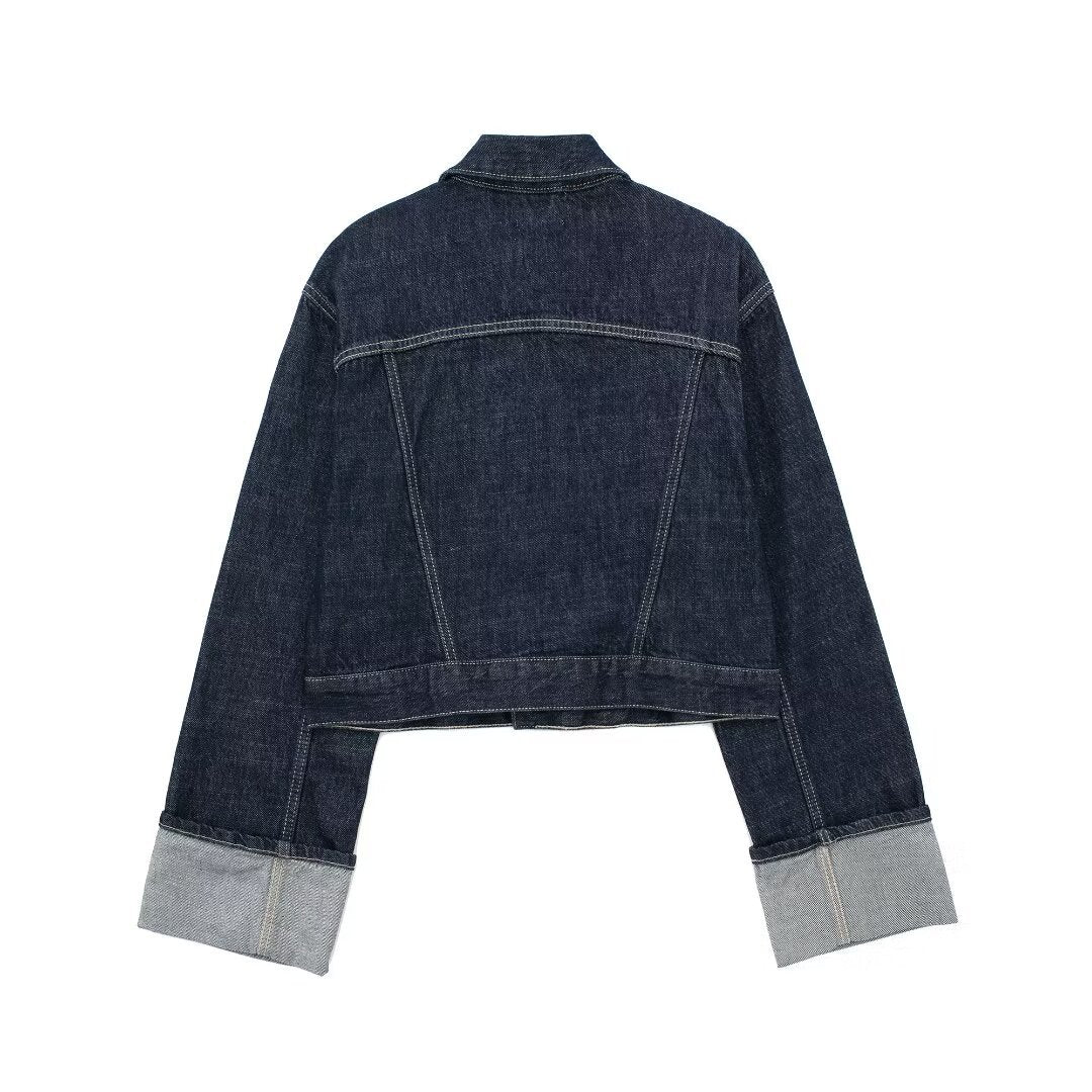 Dark indigo jacket with a boxy silhouette, rolled-up long sleeves, button-through front and neat chest pockets. Hip-skimming length and subtle paneled construction create a clean, modern layer over tees, knits or dresses for city-ready styling.