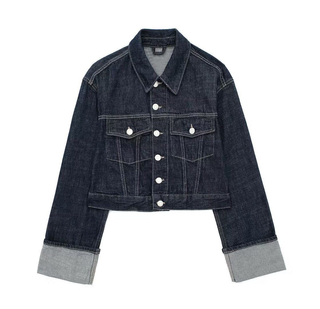 Dark indigo jacket with a boxy silhouette, rolled-up long sleeves, button-through front and neat chest pockets. Hip-skimming length and subtle paneled construction create a clean, modern layer over tees, knits or dresses for city-ready styling.